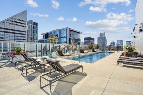 the pool on the rooftop of a building with a city in the background