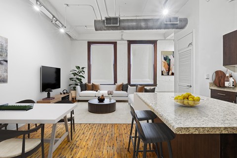 A modern kitchen and living room with a dining table and chairs.