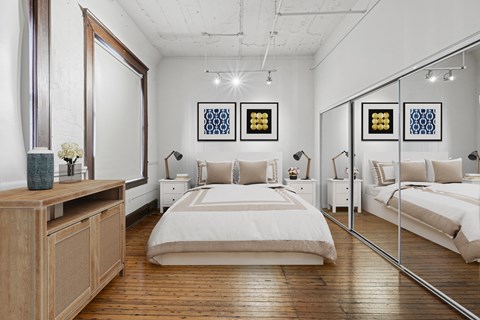A bedroom with a large bed and a wooden dresser.