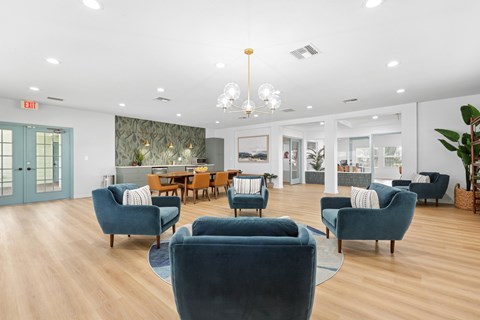 A living room with blue chairs and a wooden table.