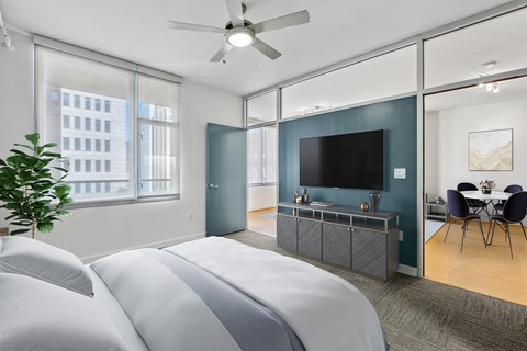 A bedroom with a large bed and a television in the corner.