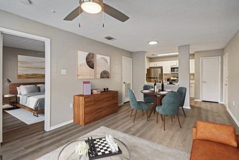 an open living room and dining room with a bed in the background and a dining
