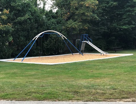 A playground with a blue arch and a slide.