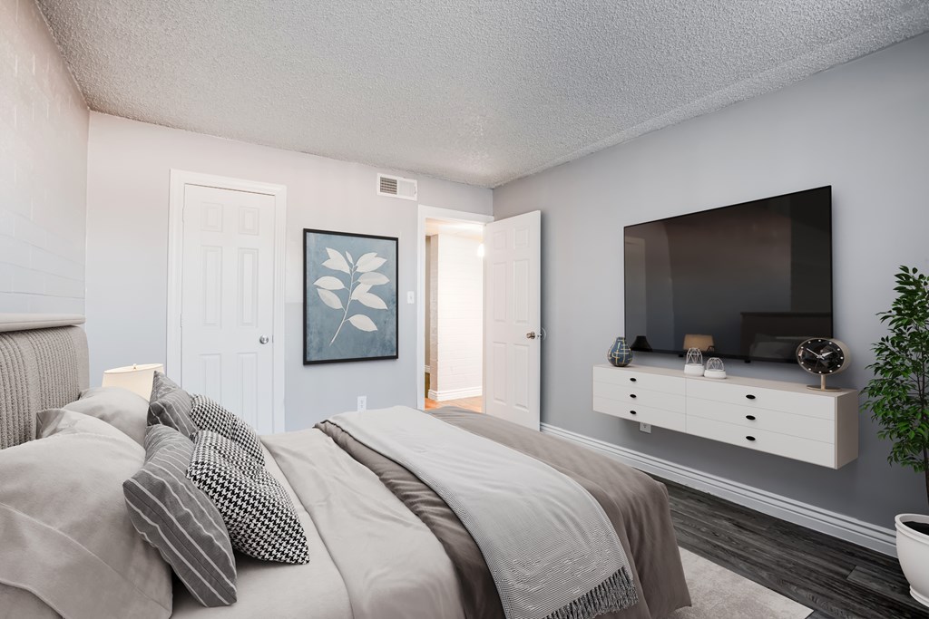 A bedroom with a bed, a dresser, and a painting on the wall.