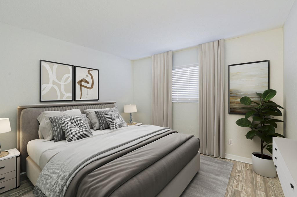 A bedroom with a large bed and a potted plant.