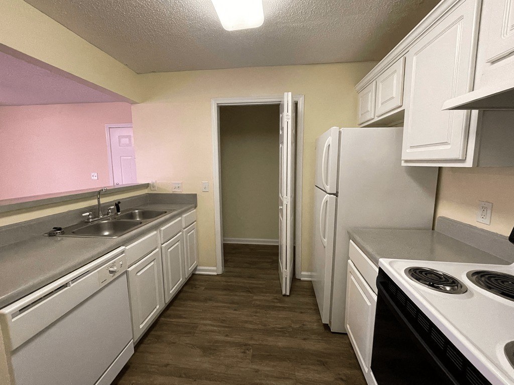 a kitchen with white cabinets and a sink and a refrigerator