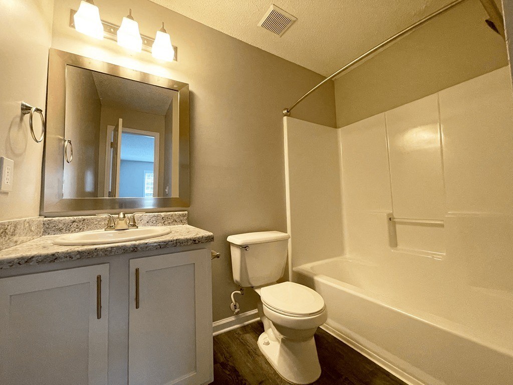 a bathroom with a toilet and a sink and a shower