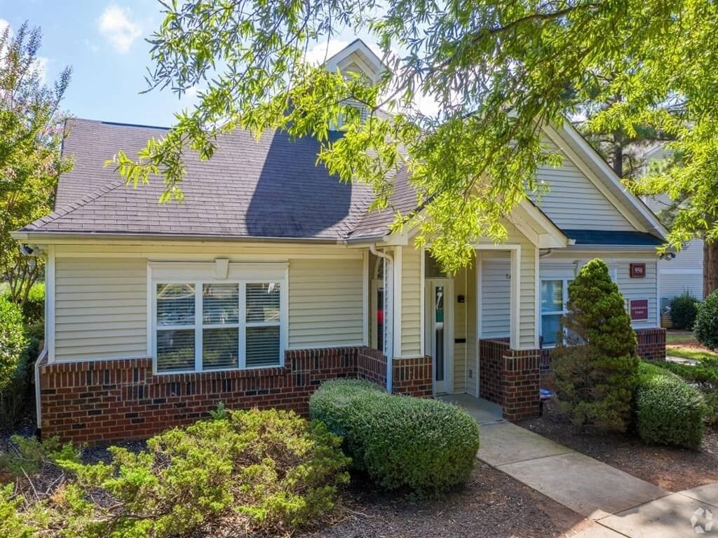 a small white house with a front porch and a sidewalk