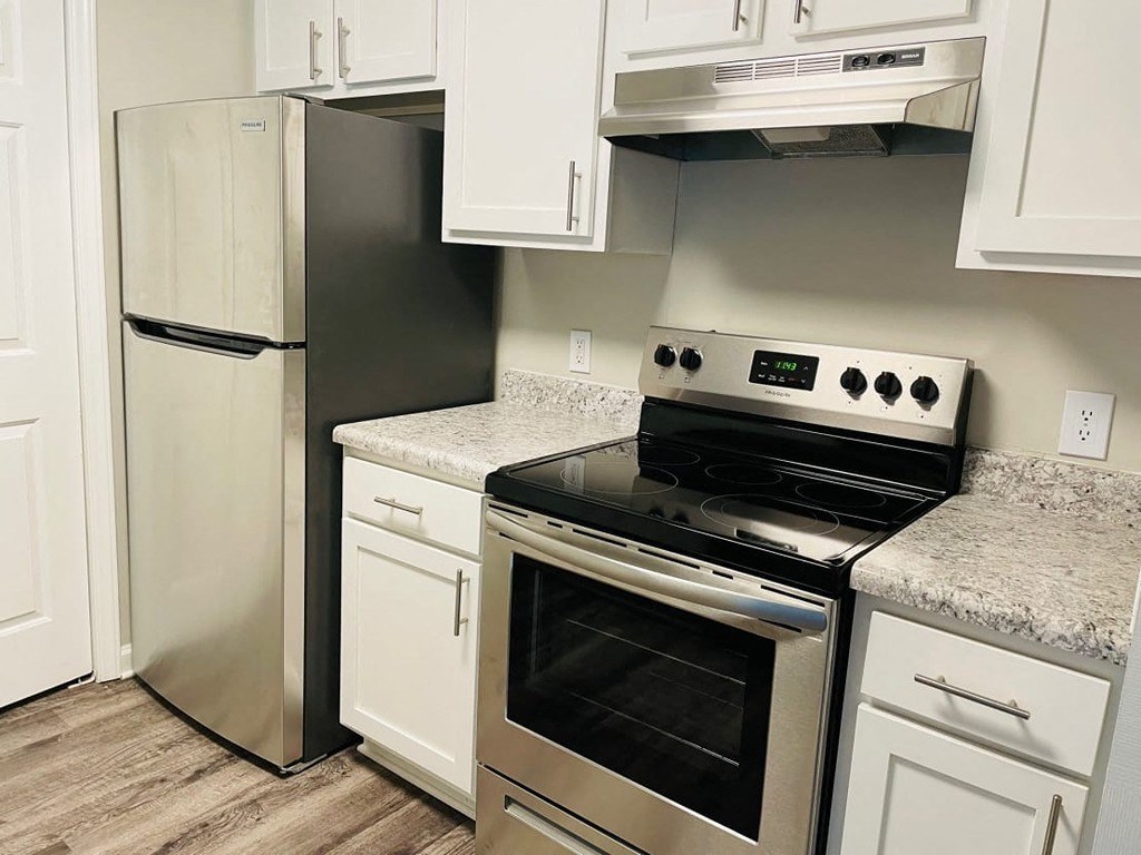 a kitchen with stainless steel appliances and white cabinets