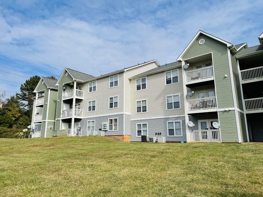 a row of apartment buildings on a grass field