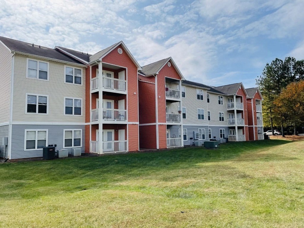 a row of apartment buildings on a grass field