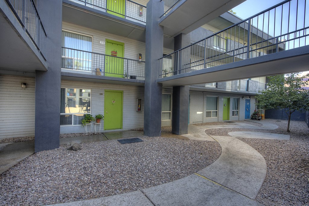 the courtyard of a building with two balconies and a green door