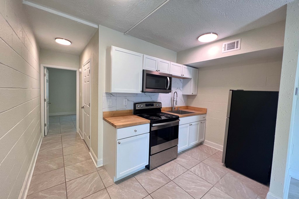 a kitchen with white cabinets and a stove and a microwave
