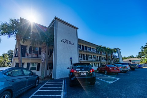 a parking lot with cars in front of an east hill building