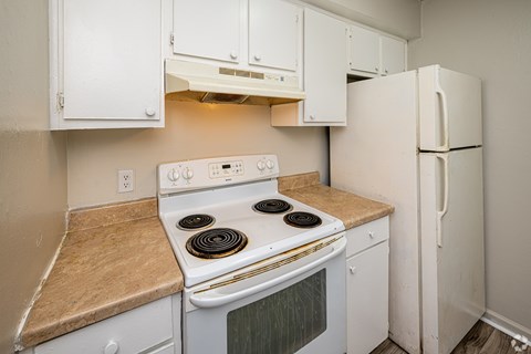 A white stove and refrigerator in a kitchen.