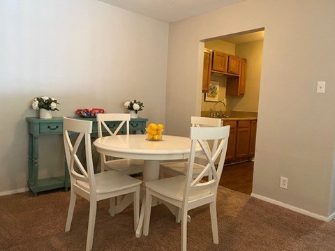 A dining room with a white table and chairs.