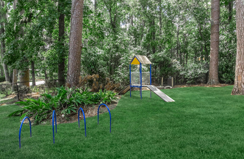 A playground with a swing set and a slide in a park.