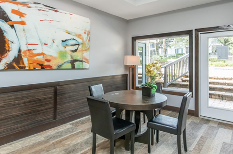 A dining room with a round table and chairs.
