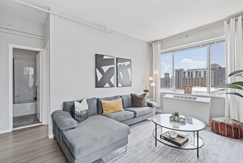 A living room with a grey couch and a coffee table.