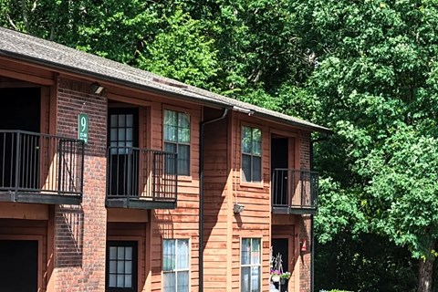 a brick apartment building with balconies and trees