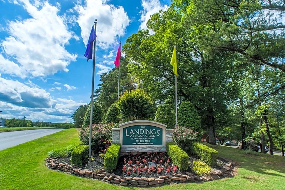 a view of a park with flags and a sign