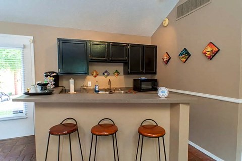 a kitchen with a counter and three bar stools