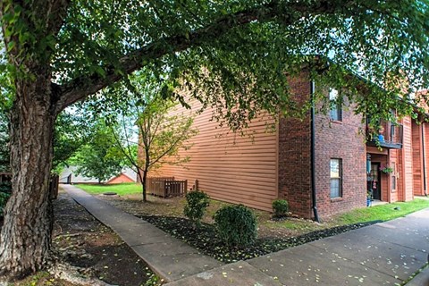 the side of a brick building next to a tree