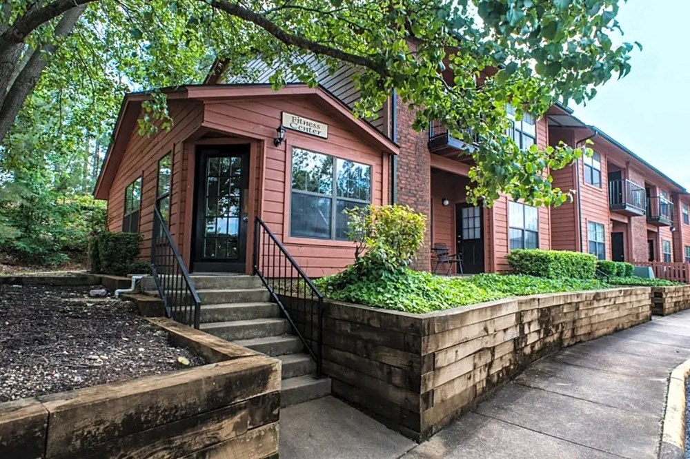 a red building with stairs and a sidewalk in front of it