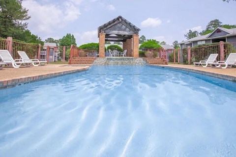a large swimming pool with a gazebo on the side of a house