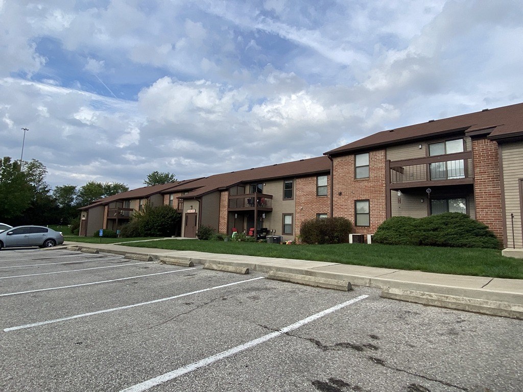 a parking lot in front of a brick apartment building