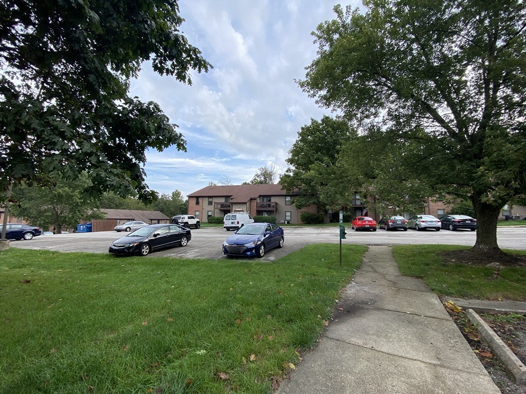 a parking lot with cars parked in front of a house