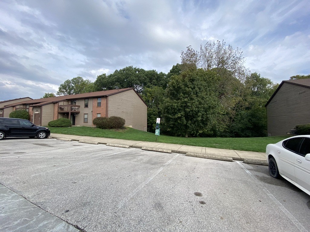 an empty parking lot in front of an apartment building