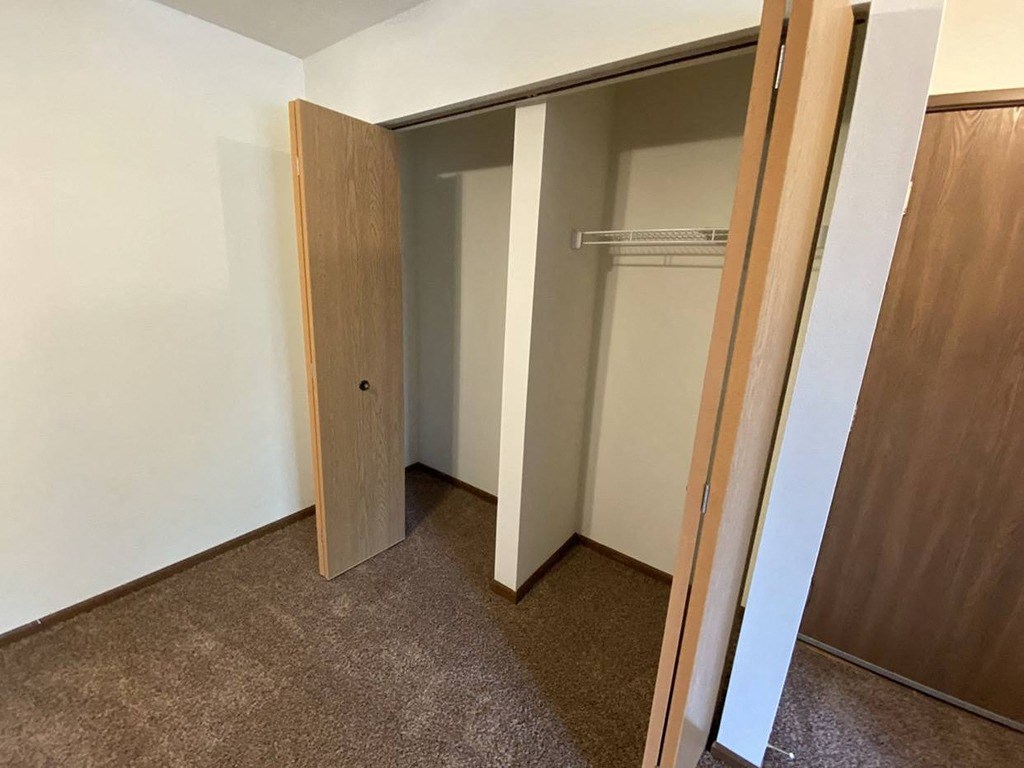 an empty closet in a room with a door open