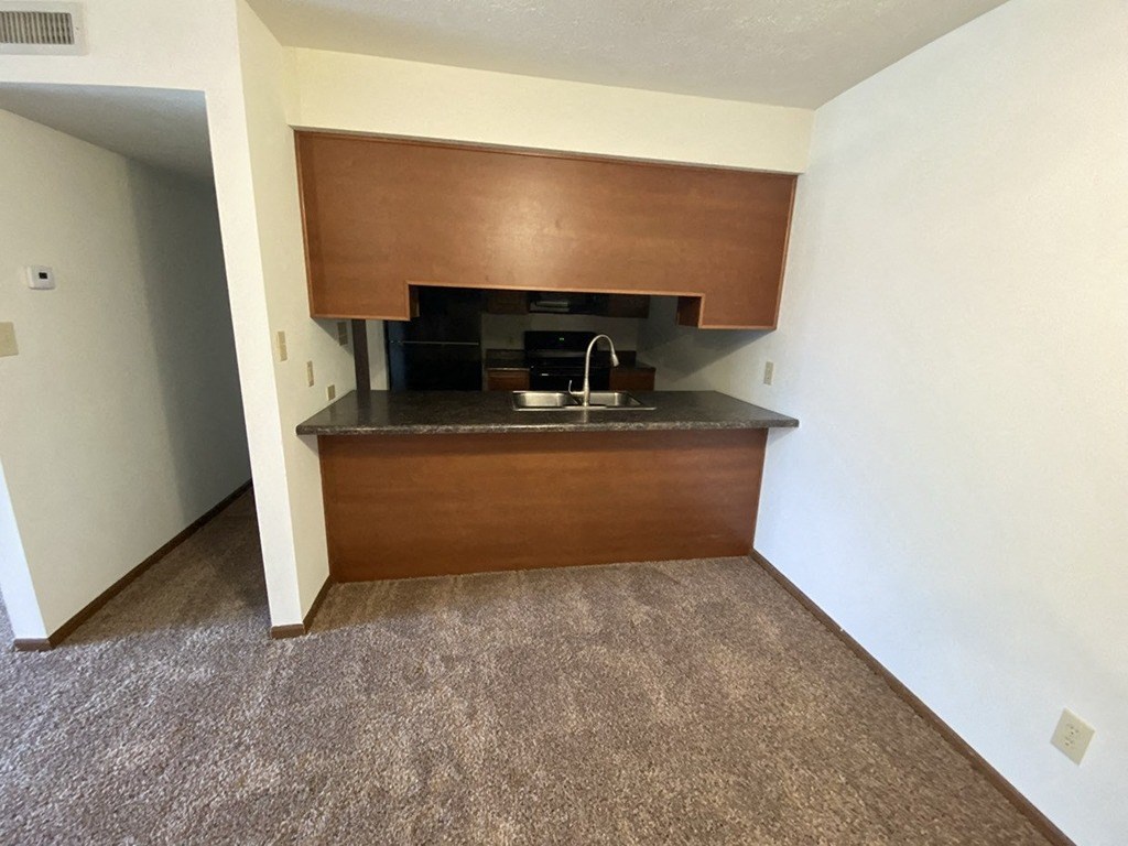 an empty kitchen with a sink and a counter