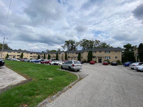 a parking lot filled with cars in front of an apartment building