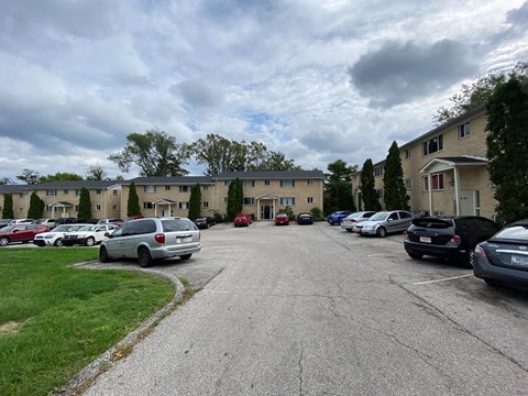 a parking lot with cars in front of apartment buildings