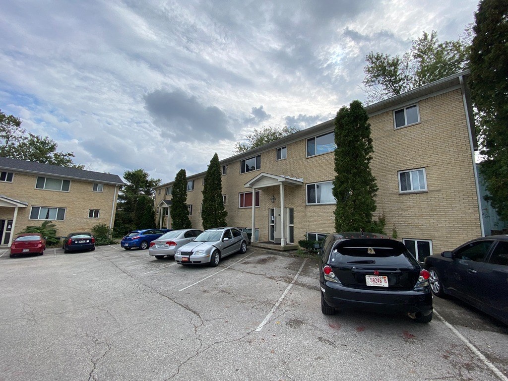 a parking lot with cars in front of an apartment building