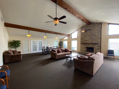 a large living room with couches and a fireplace and a ceiling fan