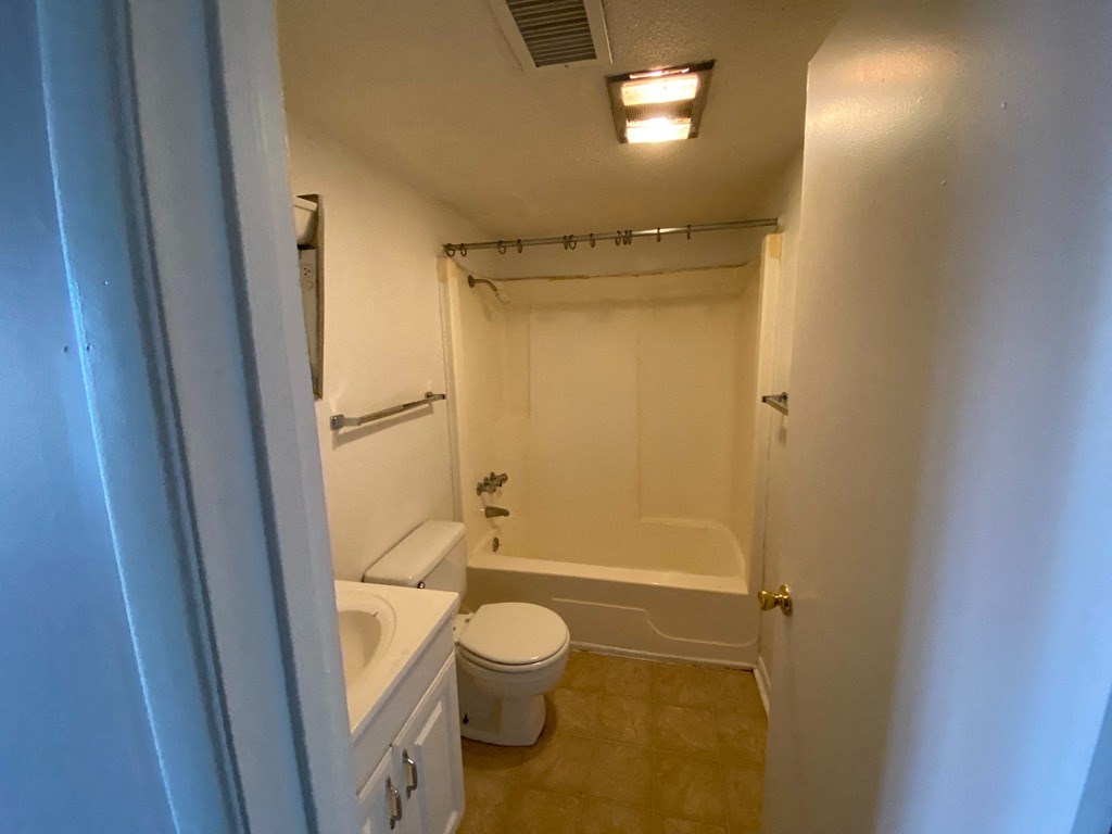 a bathroom with a toilet and a tub and a sink