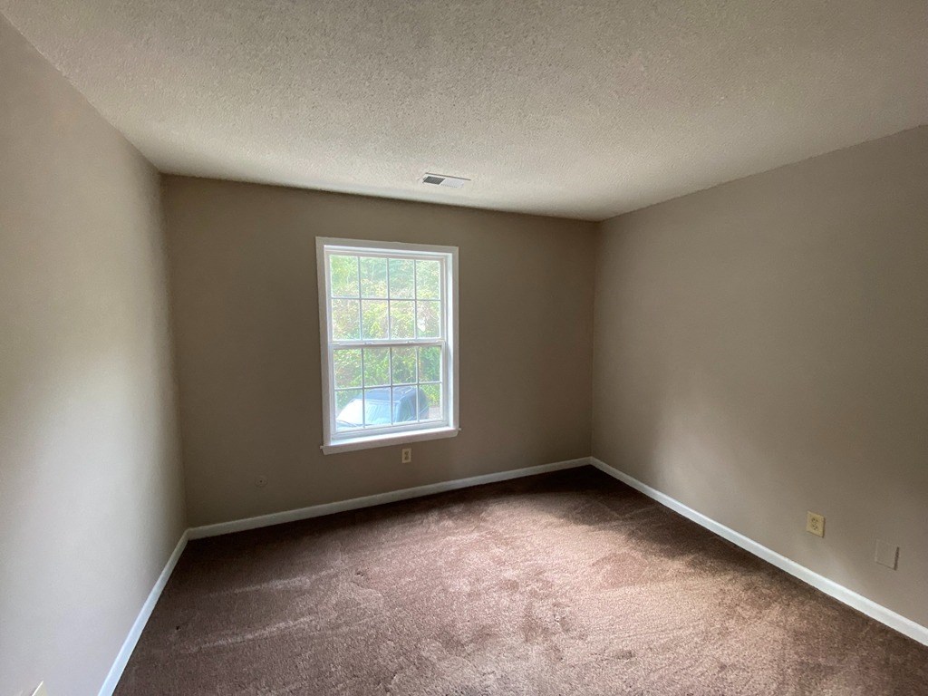 an empty room with carpet and a window