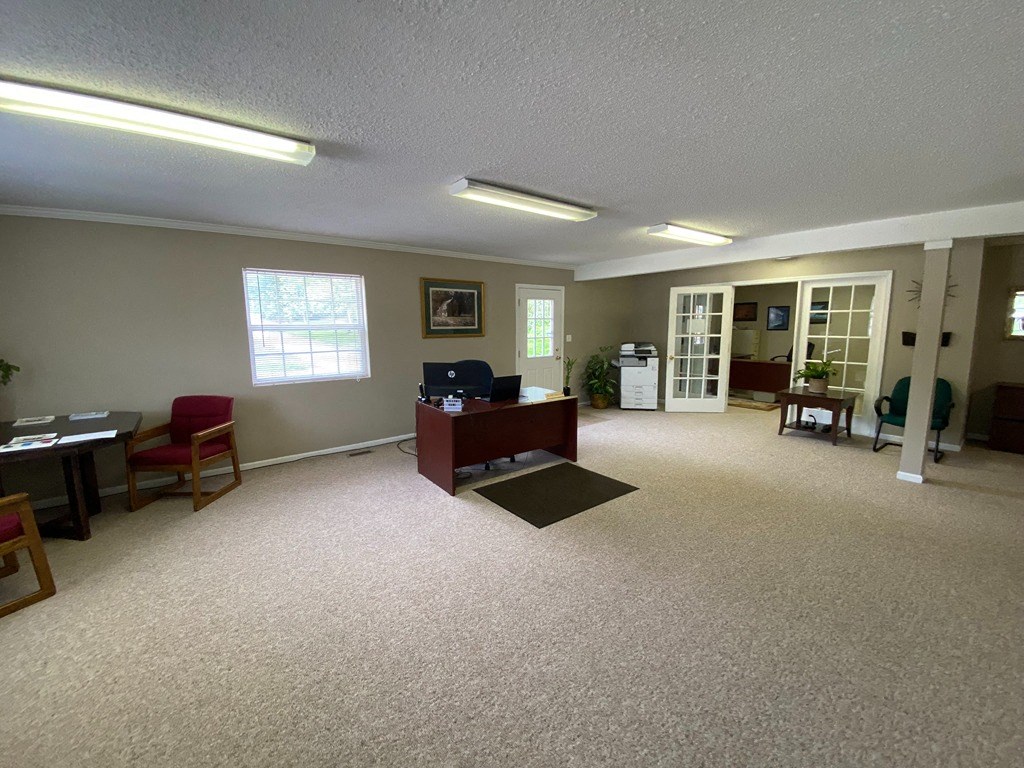 an empty living room with a desk and a chair