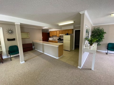 an empty living room with a kitchen and a table