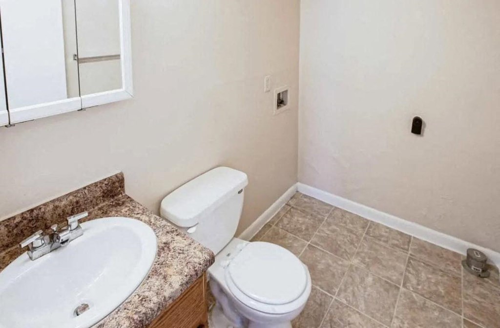 a bathroom with a sink toilet and a mirror