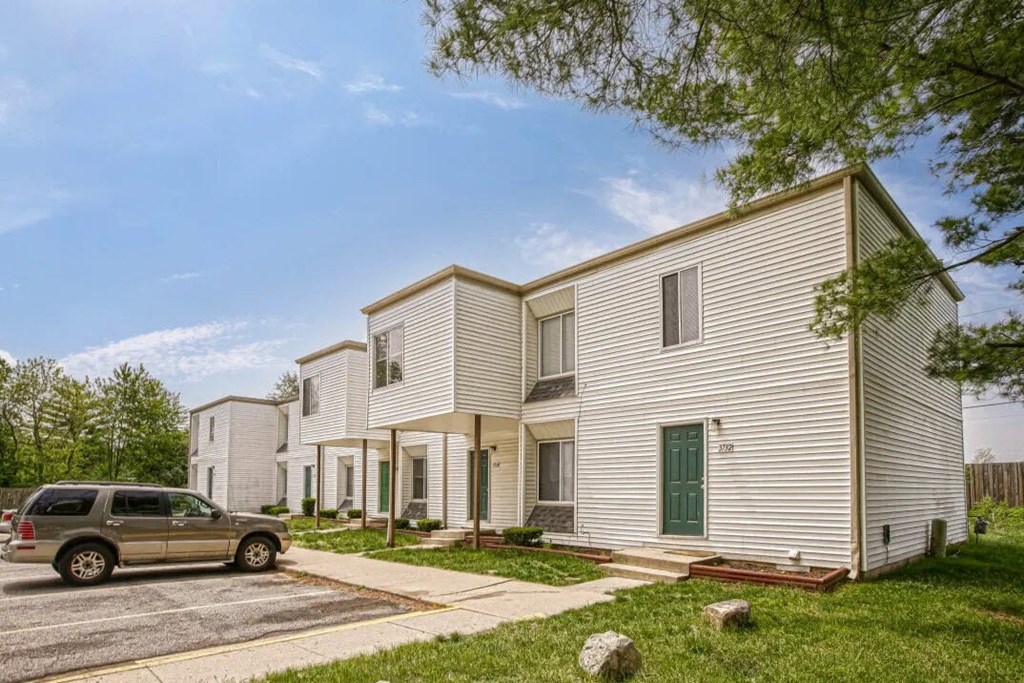 a row of houses with a car parked in the street