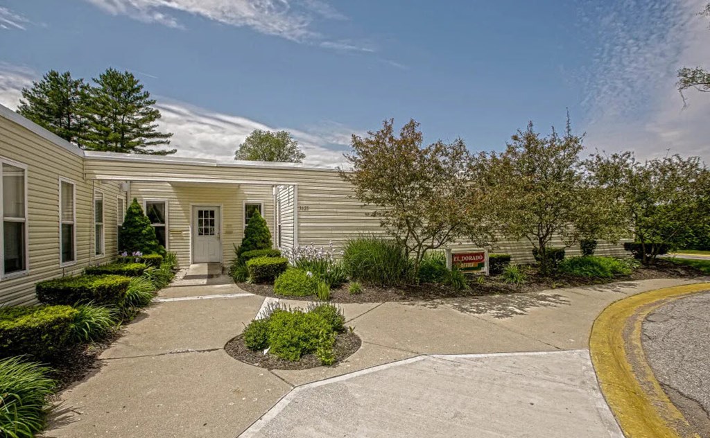 a house with a driveway and landscaping in front of it