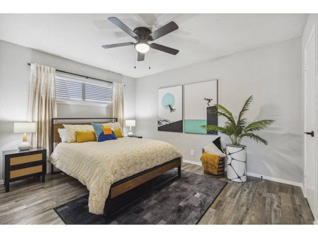 a bedroom with a bed and a ceiling fan