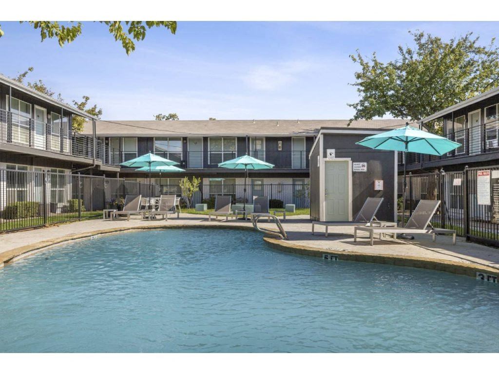 a view of a swimming pool and a building with umbrellas