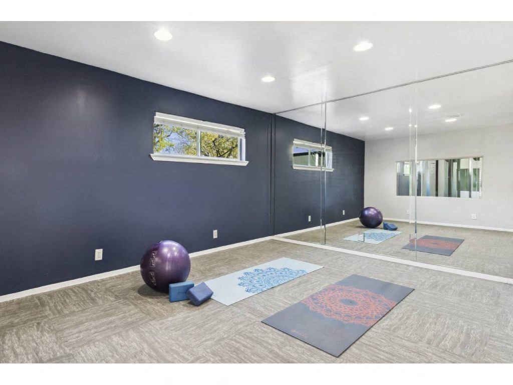 a yoga room with mirrors and yoga mats on the floor