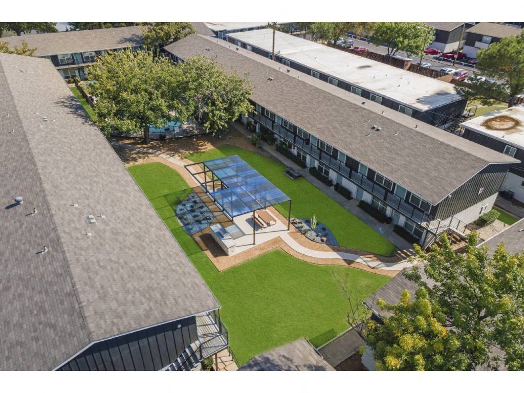 an aerial view of the roof of a building with a green yard