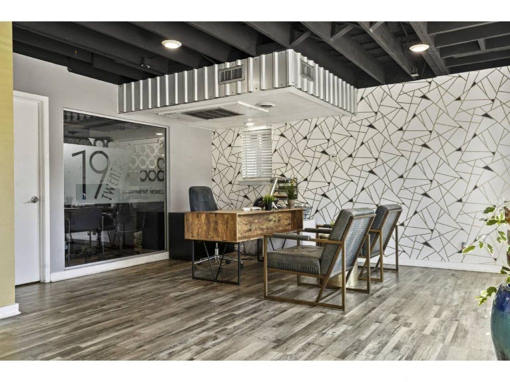 a conference room with a desk and chairs and a white wall
